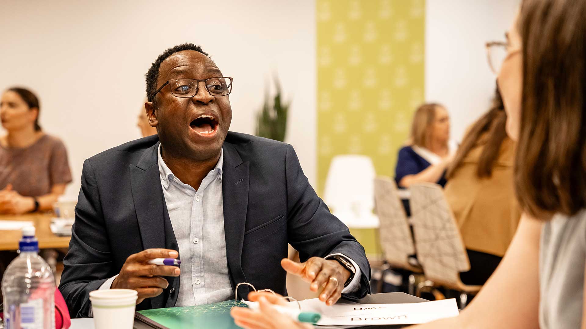 Man with a look of smiling surprise looking at the person across from him