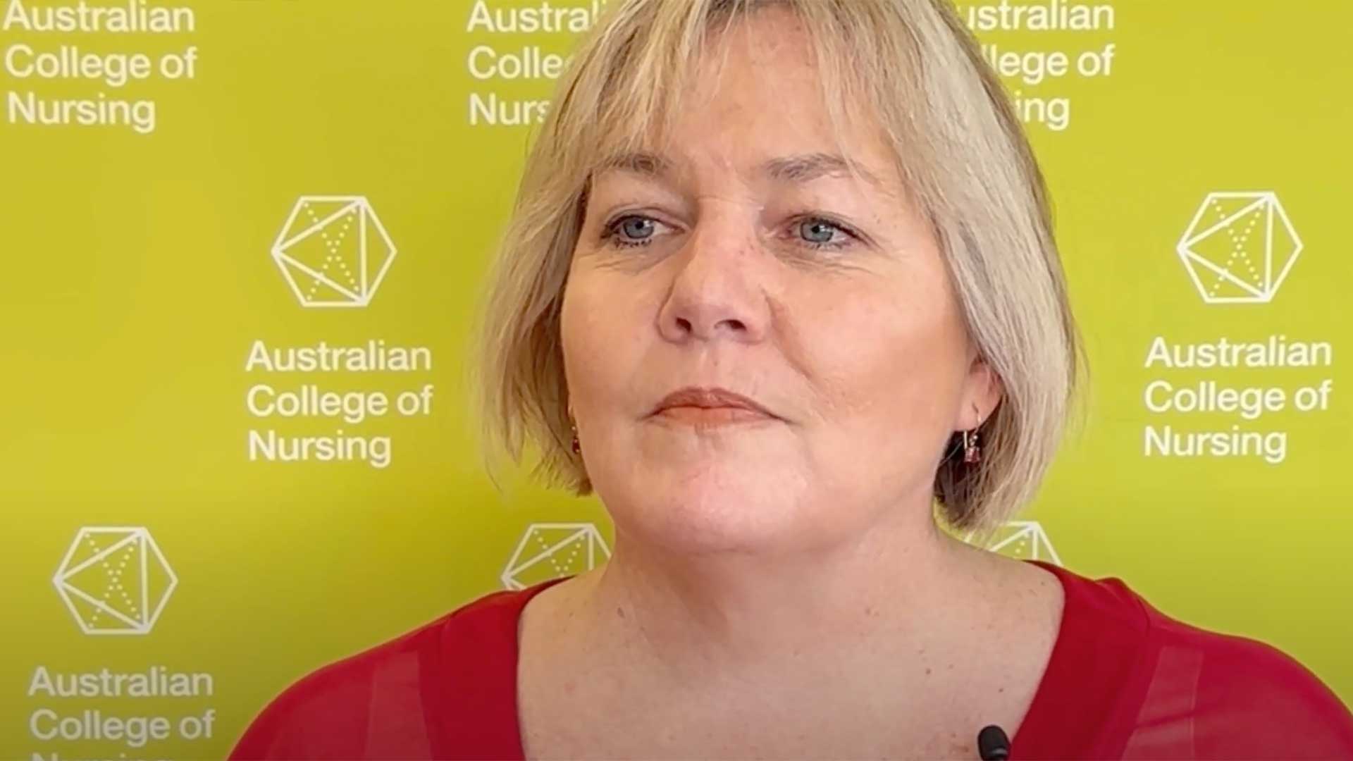 Headshot of female standing in front of an Australian College of Nursing banner